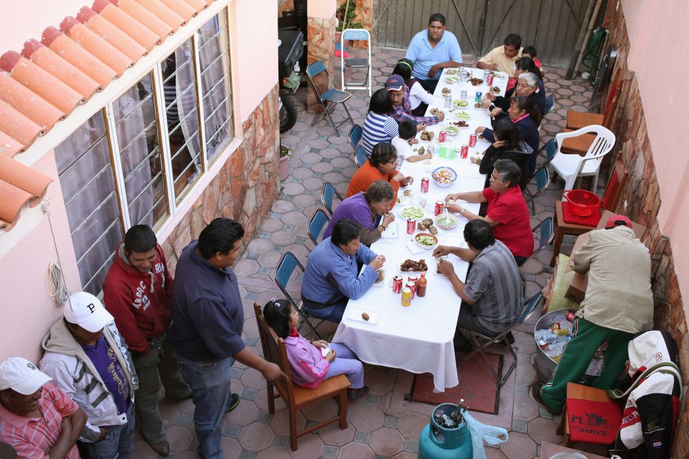 The first round of guests sits down to plates of carnitas at a Huichan family party. Photo: Alex Washburn