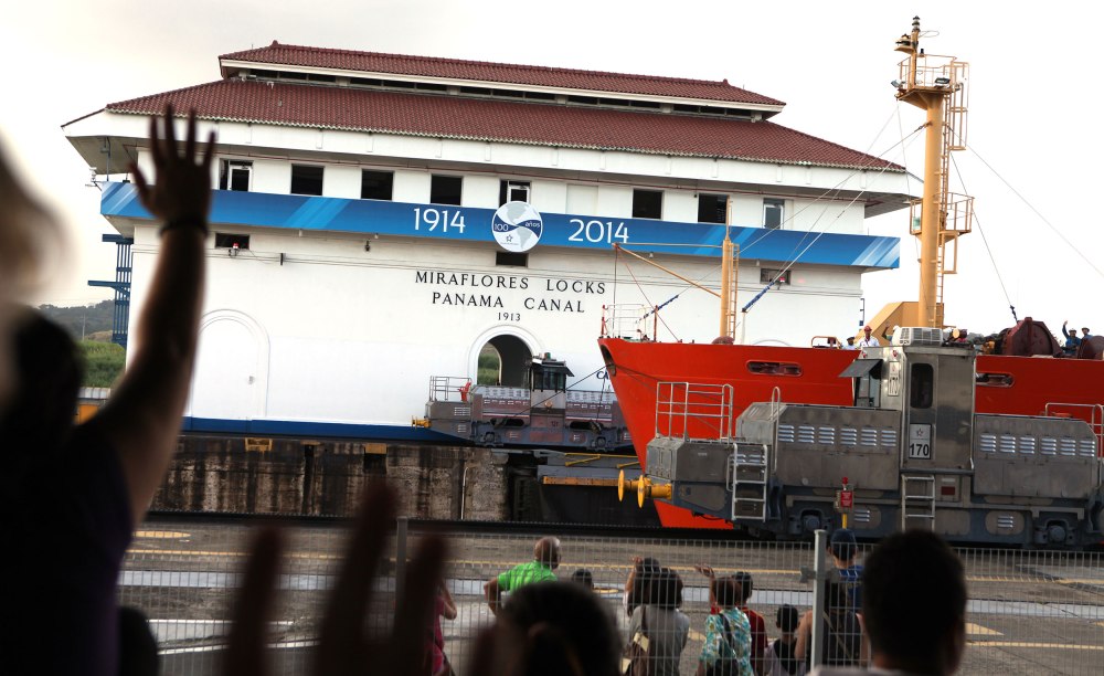 Tourists wave to a ship as it passes through the Miraflores Locks in the Panama Canal. Photo: Alex Washburn