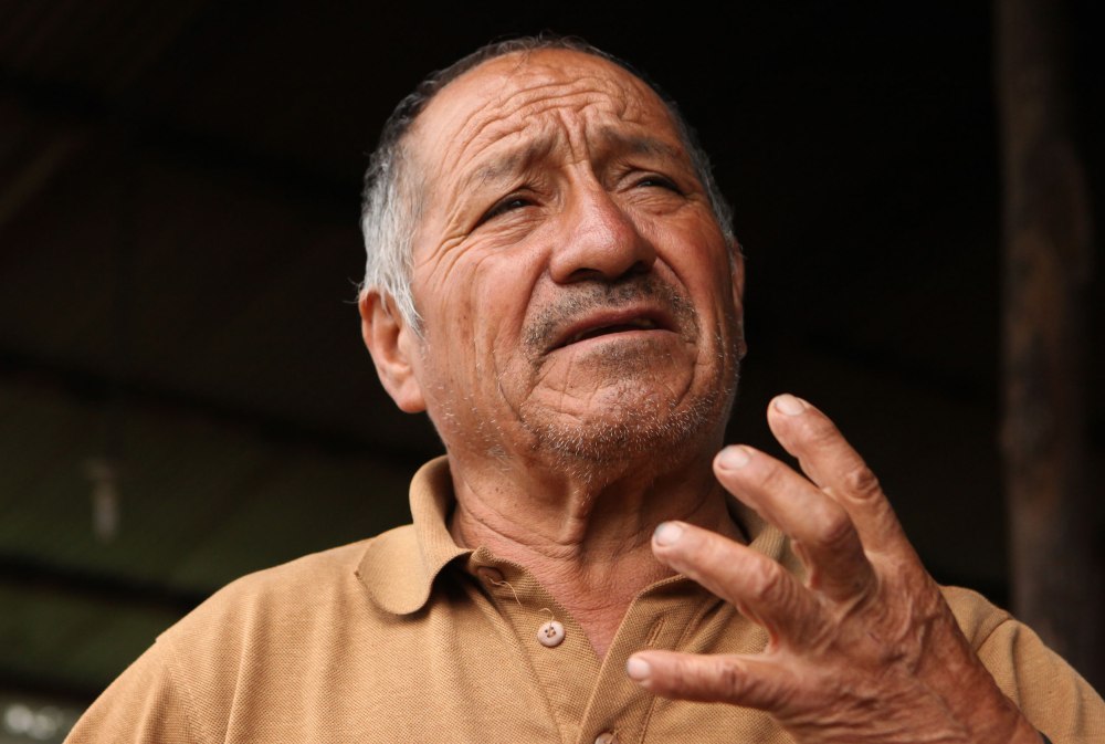 Carlos talks about his life living on the mountain watching the volcano above Baños Ecuador. His family visits him once a week (on sundays) but other than that his everyday company are his two cats, two cows and the tourists that float through. Photo: Alex Washburn