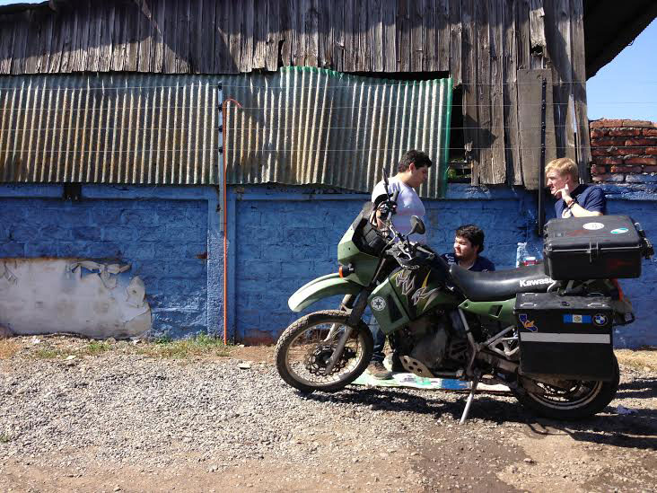 Nathaniel talks to the mechanics at the Yamaha shop in Chillán after they repaired the damage another shop did to his bike. Photo: Alex Washburn